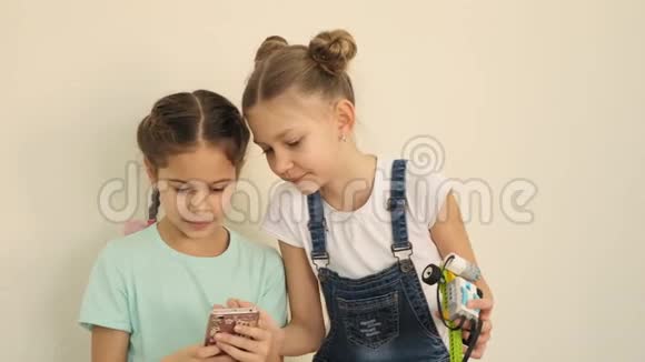 两个漂亮的女孩检查他们是否制作了良好的自拍与电子学习课慢动作构建的电子拓扑视频的预览图
