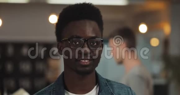 年轻的黑人微笑成功商人的肖像戴着时髦的眼镜站在现代办公室关门视频的预览图