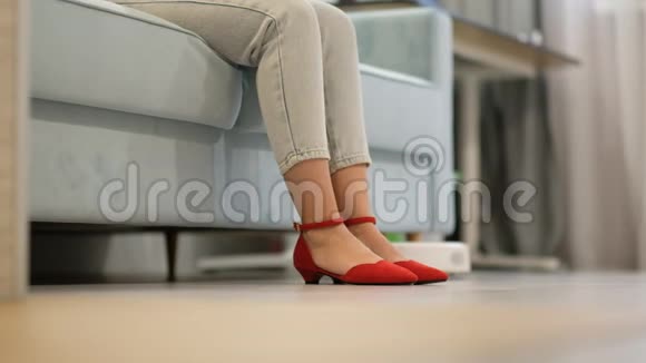 机器人吸尘器一个电子吸尘器骑在一个女人的脚下穿红鞋的女人正在休息视频的预览图