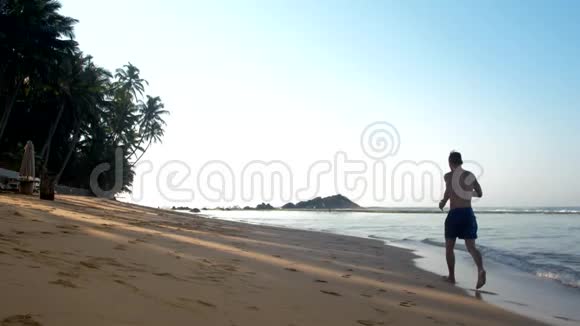 肌肉男在绿掌和海浪之间奔跑视频的预览图