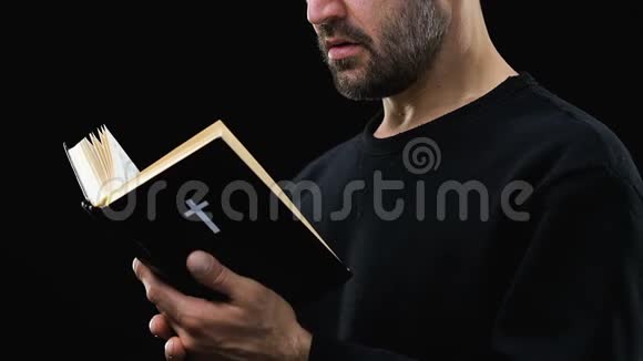 长胡子的人读圣经在黑暗的背景下祈祷上帝赞美诗视频的预览图