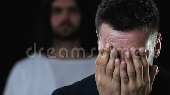 耶稣基督医治生病的哭泣的人用手闭上脸黑暗的背景视频的预览图