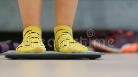 地板上穿着黄色短袜的女人穿上跑鞋去跑步或训练视频的预览图