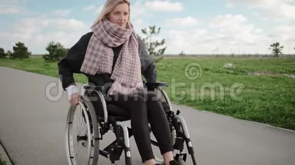 春天年轻的残疾妇女在公园里坐轮椅视频的预览图