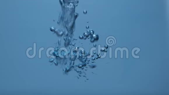 慢动作气泡在水下的抽象运动旋转的气泡在蓝色的水中喷射特写镜头视频的预览图