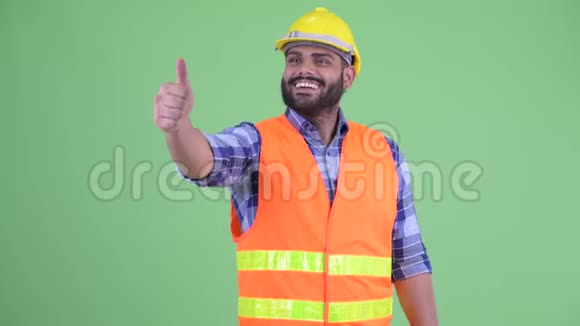 快乐的年轻超重长胡子的印度建筑工人竖起大拇指视频的预览图