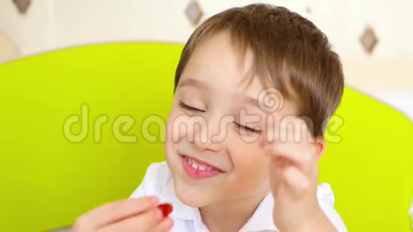 一个快乐的笑孩子的肖像一个小男孩正在吃美味的糖果视频的预览图