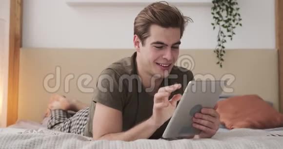男子视频聊天使用数码平板电脑床视频的预览图
