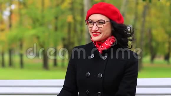 红贝雷帽里快乐的女人调整眼镜微笑视频的预览图