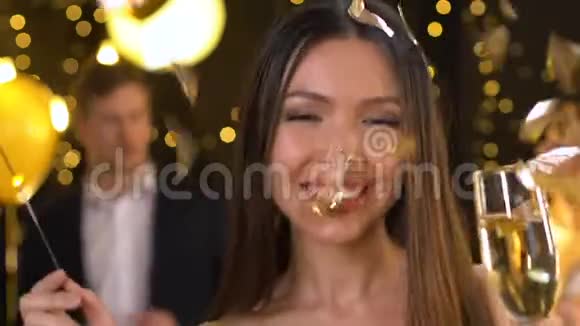 年轻漂亮的亚洲女士在新年派对上拿着孟加拉灯跳舞放松一下视频的预览图