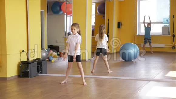 孩子们在健身房里相互滚动健身球视频的预览图