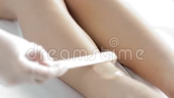 主人用木棍在女的腿上涂胶用木棍来脱毛慢动作视频的预览图
