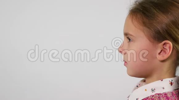 年轻女孩的脸侧写用手指嘴唇做沉默的手势视频的预览图