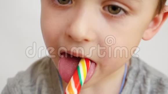 孩子把鲜艳的糖果放进嘴里吃了它特写镜头视频的预览图