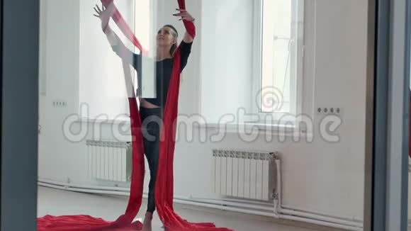 漂亮的钢管舞女在演播室里用空中丝绸视频的预览图