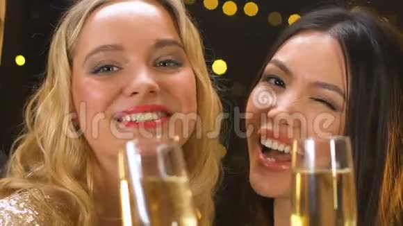 迷人的女人拿着香槟酒杯亚洲女人对着镜头眨眼视频的预览图
