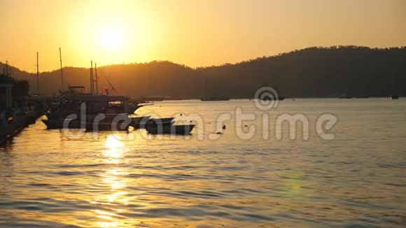 美丽的景色渔船漂浮在海面上背景是日落站在海湾的渔船视频的预览图