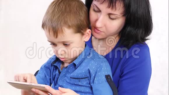 幸福家庭母子俩手里拿着智能手机触摸触摸屏妇女和儿童游戏视频的预览图