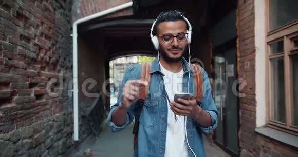 慢动作的阿拉伯嬉皮士享受音乐耳机跳舞户外视频的预览图