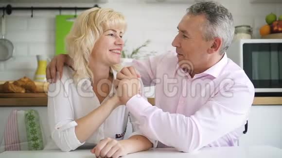 幸福的退休家庭夫妇在舒适的厨房内部视频的预览图