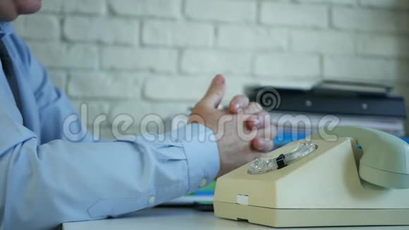 办公室里的老商人用旧电话拨电话号码视频的预览图