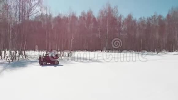 在白桦林的背景下女人在雪地里骑四轮自行车视频的预览图