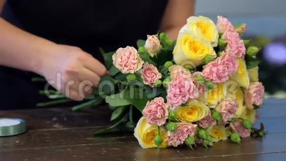 花匠制作花束玫瑰花茎与丝带手特写视频的预览图