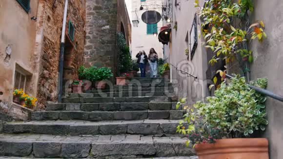两个年轻女人走上小巷的台阶喝咖啡视频的预览图