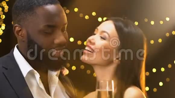 漂亮的亚洲女人亲吻黑人男性的脸颊夫妇在聚会上玩得很开心视频的预览图