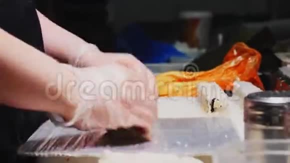 在厨房的近景中首席手套制作美味的寿司卷视频的预览图