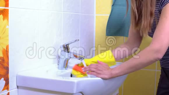 一个女人正在打扫水槽视频的预览图