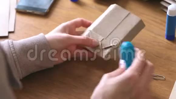 女人用牛皮纸做纸袋双手特写史塔普斯纸视频的预览图