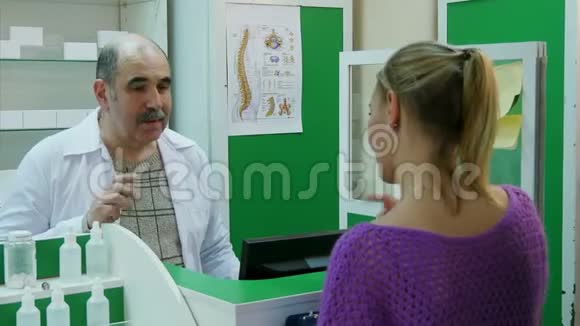 高级药剂师在药房排队时协助女顾客视频的预览图