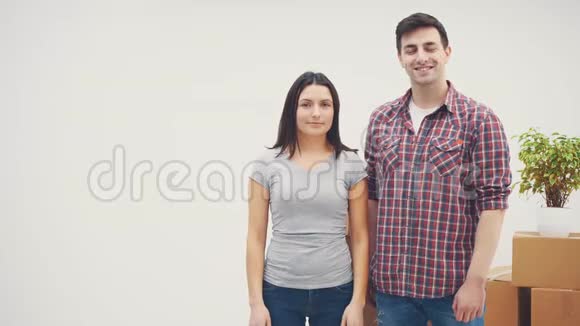高兴的男人和女人站在新公寓里微笑着男人在展示钥匙女人在放弃拇指视频的预览图