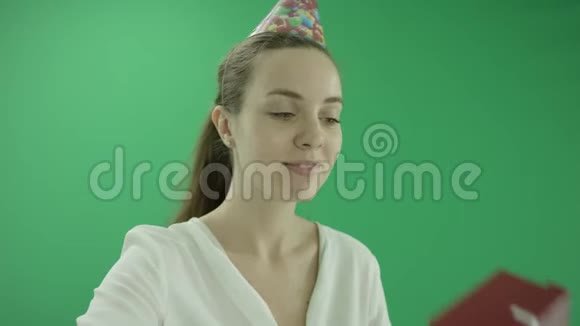 令人惊讶的兴奋的女人笑着戴着生日帽展示了一件礼物她穿正装女士站得很近视频的预览图