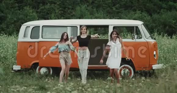 令人惊叹的三位女士在一辆橘色老式货车前的舞蹈中非常有魅力视频的预览图