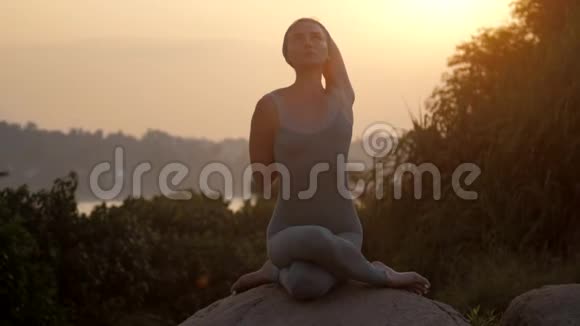 女人是不是奶牛面对阿萨纳坐在巨大的石头慢动作视频的预览图