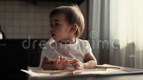 小可爱的小女孩坐在桌子旁玩铅笔视频的预览图