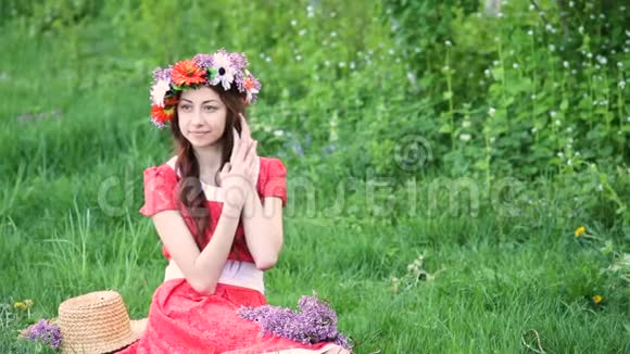 戴着花环的美女在草地上采花快乐的女人在春天或夏天我喜欢和植物一起工作视频的预览图