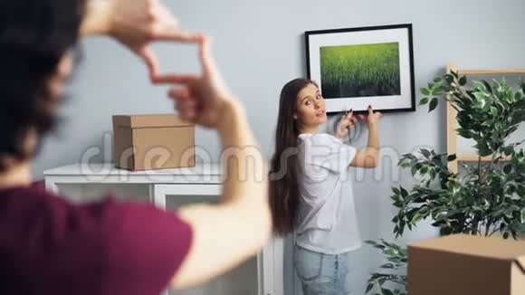 丈夫和妻子在新房子里挑选照片交谈和手势视频的预览图