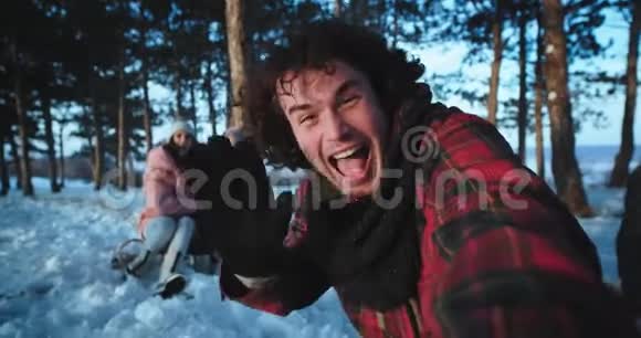 有魅力的游客用他的相机制作了一段视频并在背景上捕捉到了冬天下雪时的两位女士视频的预览图