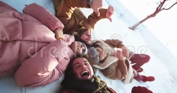 多民族的朋友拍一个自拍视频他们躺在地板上在前面做一张滑稽的脸视频的预览图