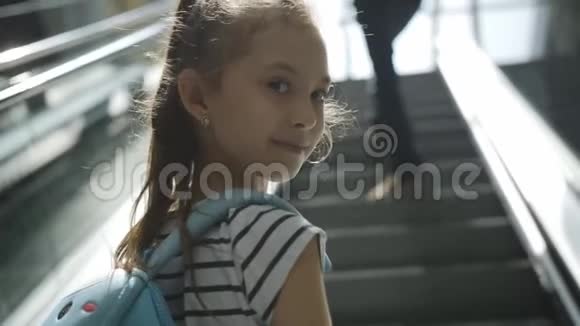 她登上自动扶梯来到机场候机楼的下一层视频的预览图