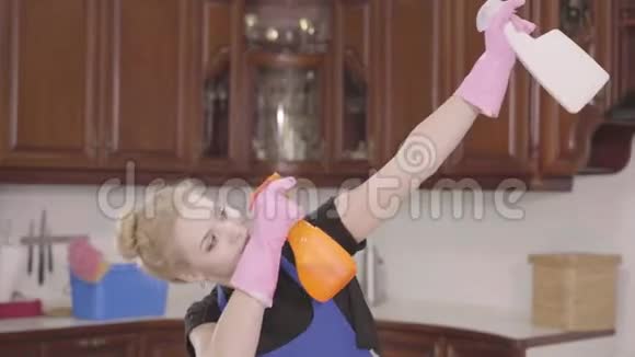 年轻漂亮的女人把洗洁精的瓶子举起来到处胡闹清洁日家务家务家务家务家务视频的预览图