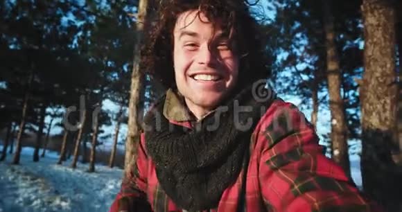 非常有魅力的游客带着微笑独自在森林中旅行拿着摄像机捕捉他的照片视频的预览图