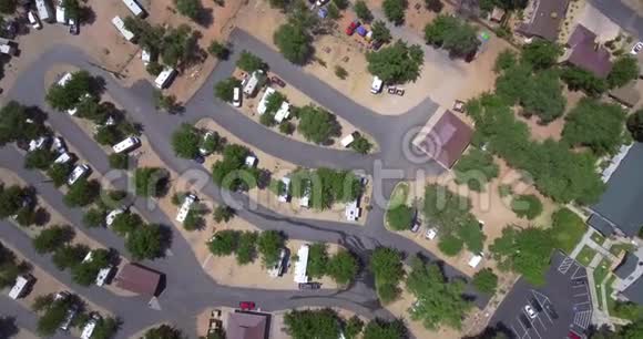 头顶上的空中摄像机放大到停车场几栋房子之间有汽车和树木视频的预览图