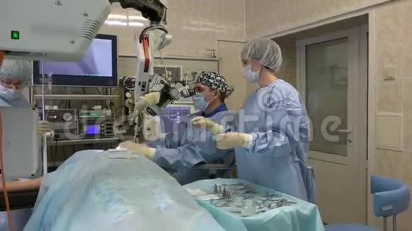 手术室的一组外科医生用外科显微镜对耳鼻喉科器官进行显微手术视频的预览图