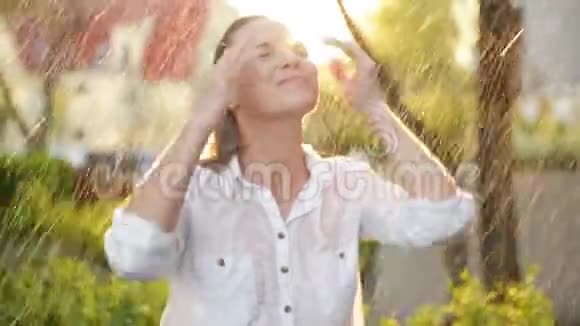美丽的女人湿发享受雨仰望天空夏日花园里的美女有很多视频的预览图