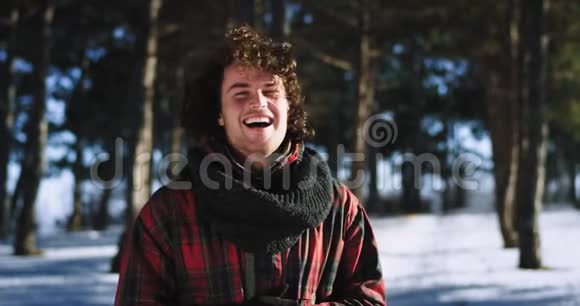微笑卷发男游客在镜头前快乐地享受镜头前的冬日时光视频的预览图