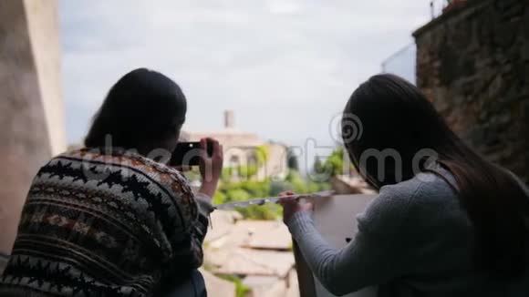 两个女人坐在楼梯旁其中一个人画画然后另一个女人得到一个照片相机视频的预览图